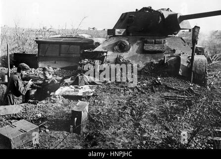 The Nazi propaganda image shows German Wehrmacht soldiers in a ground bunker in front of a destroyed T-34 Soviet tank in Stalingrad (today Volgograd). Taken in November 1942. A Nazi reporter has written on the reverse of the picture on 26.11.1942, 'The fighting for Stalingrad. A burn-out T 34 used for protection against bombs and shrapnel for a German ground bunker.' Fotoarchiv für Zeitgeschichte - NO WIRE SERVICE -  | usage worldwide Stock Photo