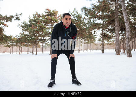 Young afro american man taking a break while doing winter fitness session Stock Photo