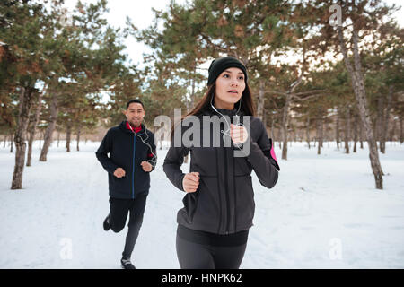 Young fitness couple running outdoors on a winter day Stock Photo