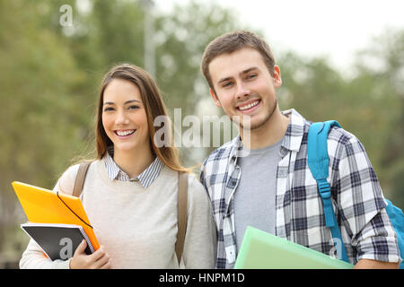 Two students posing looking at you outdoors in an university campus Stock Photo