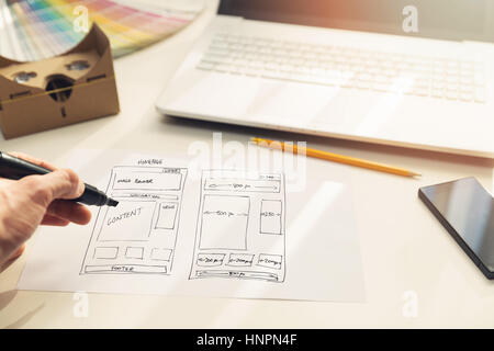 designer drawing website development wireframe on paper in office Stock Photo
