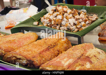 Cooking roasted crispy pork belly placed on a banana leaf for sale at outdoor Stock Photo