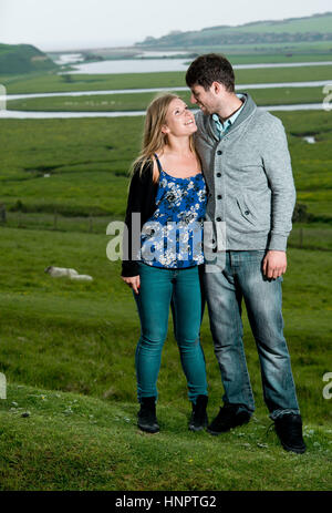 A couple recently engaged show their love for each other near seven sisters, East Sussex, UK. Stock Photo