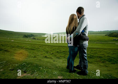 A couple recently engaged show their love for each other near seven sisters, East Sussex, UK. Stock Photo