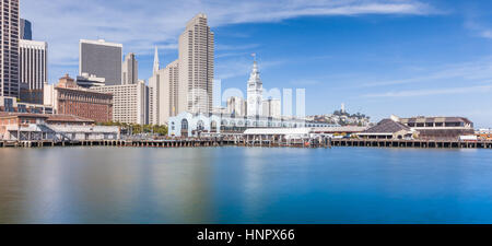 Panoramic view of San Francisco skyline with historic Ferry Building at famous Embarcadero street on a sunny day with blue sky and clouds, California Stock Photo