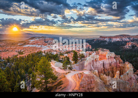 Classic view of Bryce Canyon National Park in beautiful golden morning light at sunrise with blue sky and dramatic clouds, American Southwest, Utah Stock Photo