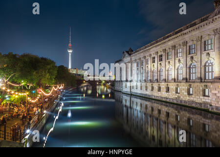 People dancing at summer Strandbar beach party near Spree river at Museum Island with famous TV tower in the background at night, Berlin, Germany Stock Photo