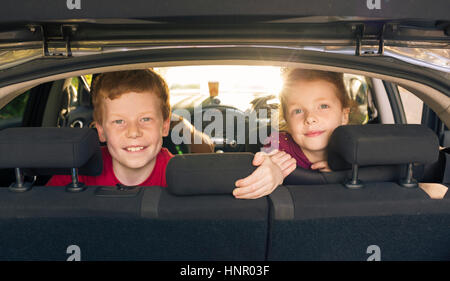 Children looking through the hatchback opening in a car Stock Photo