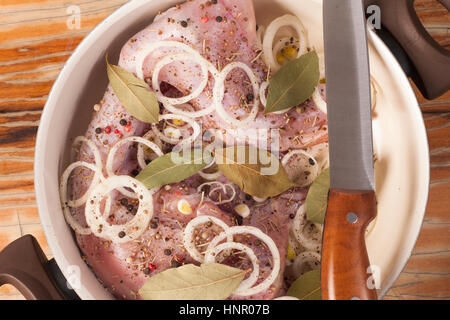 raw rabbit on a wooden Board with ingredients for stewing onion,  bay leaf, rosemary and suer cream on a wooden background - top view Stock Photo