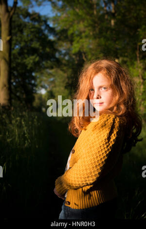 Portrait of an 8 year old girl with ginger hair outdoors Stock Photo