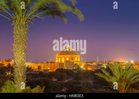 Mosta, Malta - The Mosta Dome or The Church of the Assumption of Our Lady, commonly known as the Rotunda of Mosta with palm tree by night Stock Photo
