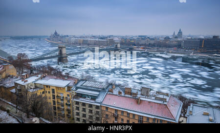 Budapest, Hungary - Panoramic skyline view of the Szechenyi Chain Bridge on the icy River Danube with Parliament and Bazilika at background on a winte Stock Photo