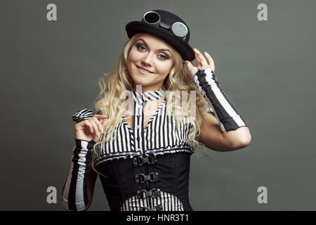 Beautiful steampunk lady in a Victorian style wears a bowler hat Stock Photo