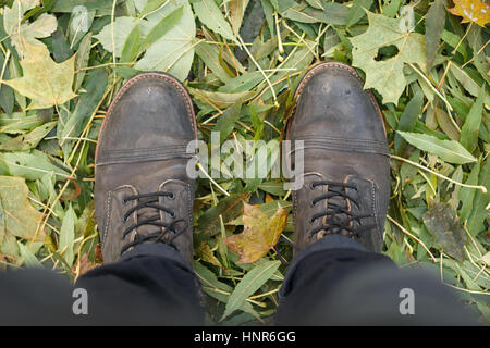 Boots standing on fallen leaves Stock Photo