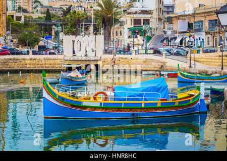 St.Julian's, Malta - Traditional colorful Luzzu fishing boat at Spinola bay at sunrise Stock Photo