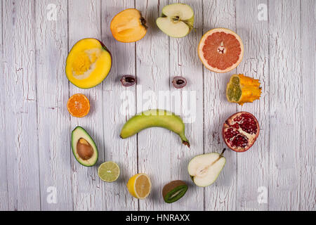 Halved fruits on a wooden board making sad face shape Stock Photo