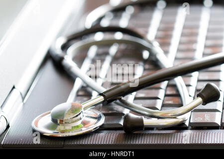 Stethoscope on black laptop computer medical technology concept with blurred background Stock Photo