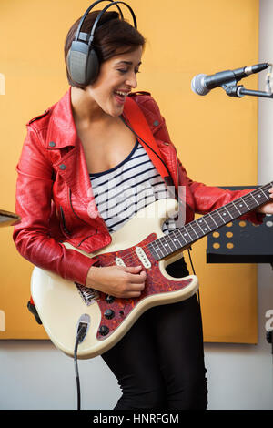Happy Signer Playing Guitar In Recording Studio Stock Photo
