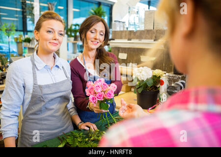 Florists Selling Rose Bouquet To Customer In Shop Stock Photo