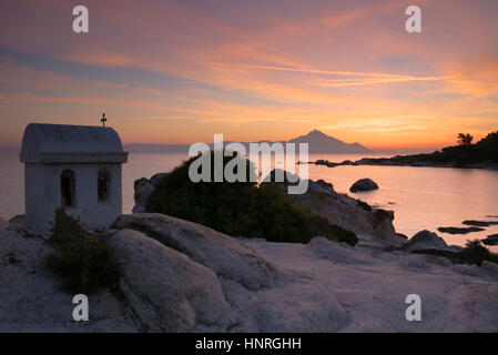 The amazing silhouette of mount Athos rising from the Aegean sea and symbol of Greek orthodox Christianity at sunrise. Stock Photo