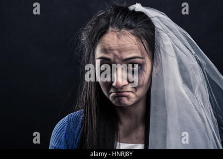 Disheveled bride with tear-stained face on black background. Studio photo shoot Stock Photo