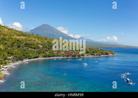 Jemeluk Beach and beautiful blue lagoon with Gunung Agung volcano on background. Amed village, East of Bali, Indonesia. Stock Photo