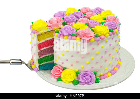 Pastel Rainbow Yellow, Pink, Purple butter cream frosting handmade roses on a round cake with dots of buttercream frosting border. Sliced showing rain Stock Photo