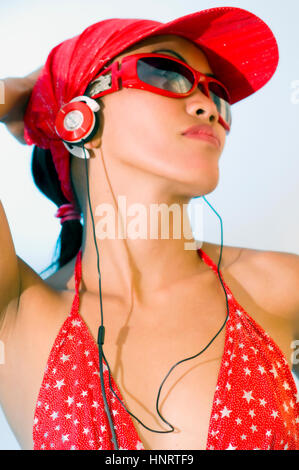 Young Asian woman with earphones in studio setting Stock Photo