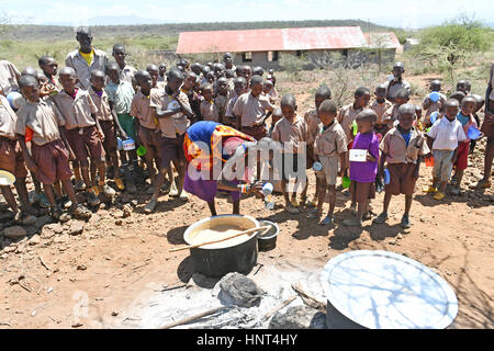 Kajiado, Kenya. 16th February, 2017. Students wait in line for their lunch, porridge cooked with government aid food, at Olomayiana West Primary School in Kajiado County, Kenya, Feb. 15, 2017. The Kenyan government last Friday declared the current drought affecting 23 arid and semi-arid counties and pockets of other areas a national disaster. The UN Food and Agriculture Organization (FAO) have warned that Kenya is facing a severe drought and with it a rise in food insecurity. Credit: Xinhua/Alamy Live News Stock Photo
