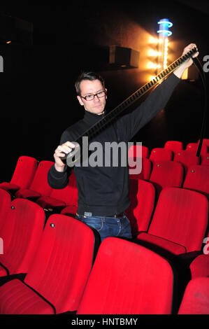 Frankfurt, Germany - January 5, 2011 - Cinema operator looking at film strip in old fashioned cinema. Owner is forced to shut down his business becaus Stock Photo