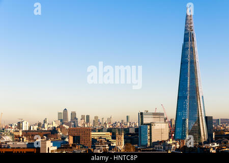 Financial district cityscape of London, including Canary Wharf and The Shard against a blue cloudless sky Stock Photo