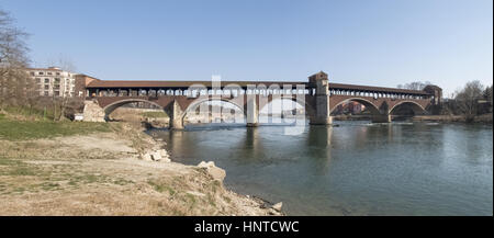 Pavia, Italy - March 8, 2015: Covered bridge over the river Ticino. Very quaint, has five arches and is completely covered with two portals at the end Stock Photo