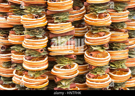 Sliced dehydrated oranges, bay leaves and cinnamon sticks in hanging garlands. Fragrant natural air freshening Stock Photo