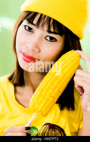 Young Asian woman with corn cob Stock Photo