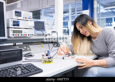 A female electronics student studying in an electronics engineering lab. Stock Photo