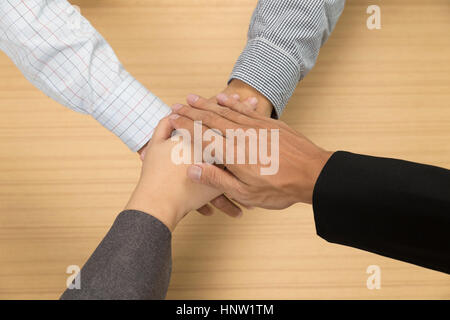 businessmen put their hand together for use as unity, cooperation and teamwork concept Stock Photo