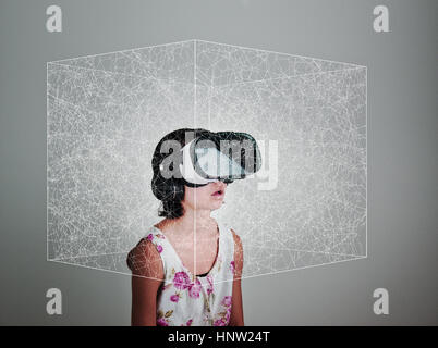 Mixed Race girl wearing virtual reality goggles in floating box Stock Photo
