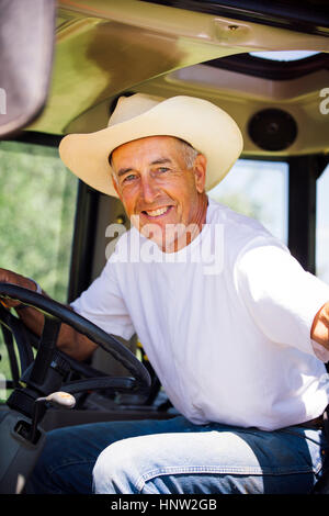 Portrait of smiling Caucasian farmer in tractor Stock Photo