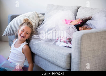 Laughing girls playing on sofa Stock Photo