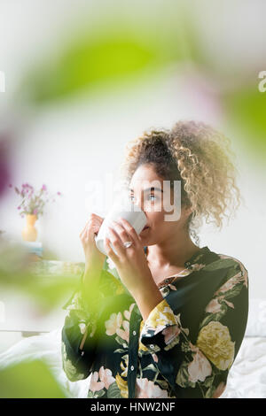 Mixed Race woman drinking coffee Stock Photo