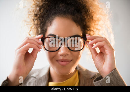 Mixed Race woman adjusting eyeglasses Stock Photo