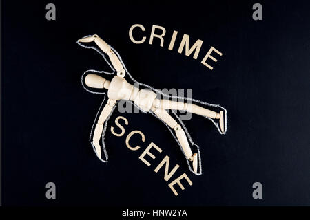 wooden dummy figurine laying on the floor with chalk outline - crime investigation concept Stock Photo