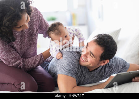 Hispanic mother holding baby daughter on back of father Stock Photo