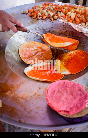 Hand flipping fresh tortillas in pan Stock Photo