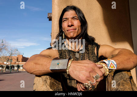 Native American man sitting against post Stock Photo
