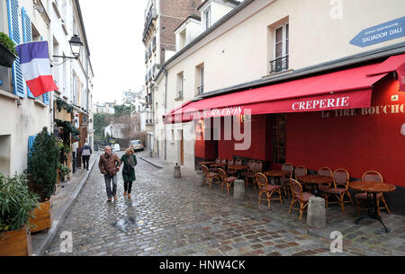 Montmartre, Paris. two people walk along a cobbled street in Montmartre Village,  Paris Stock Photo