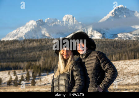 Caucasian couple smiling near mountains in winter Stock Photo