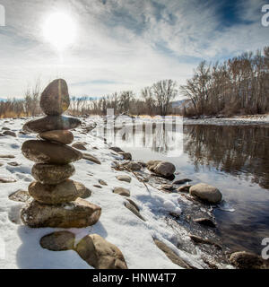 Pile of rocks balancing near river Stock Photo