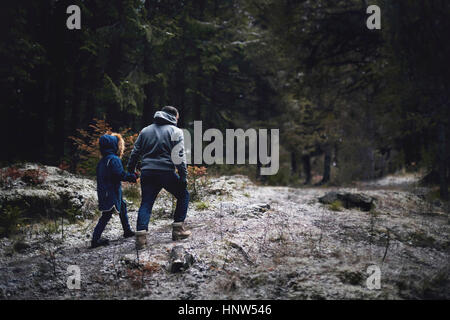 Caucasian father and daughter walking in woods