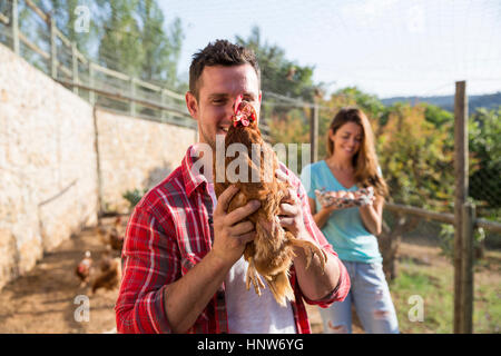 Portrait of organic farmer holding free range chicken Stock Photo